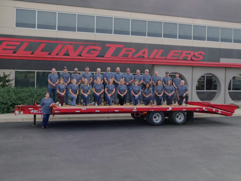 Operations and administration team posed on a Felling Trailer
